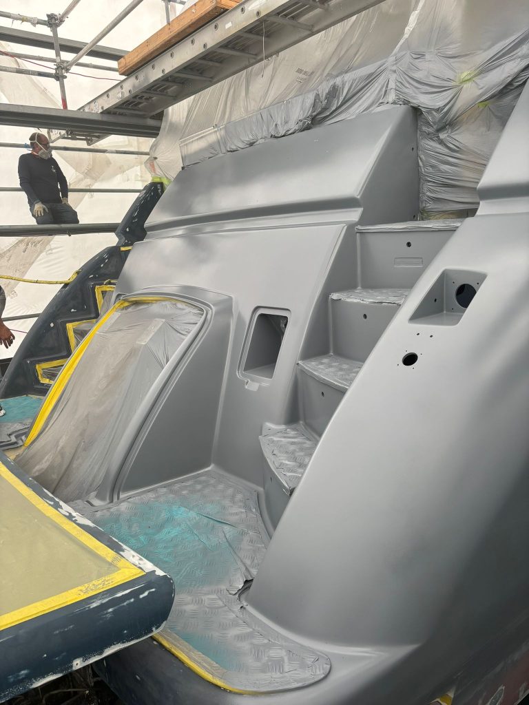 Blue Azimut stern in grey primer with protected steps and hatch inside the enclosure