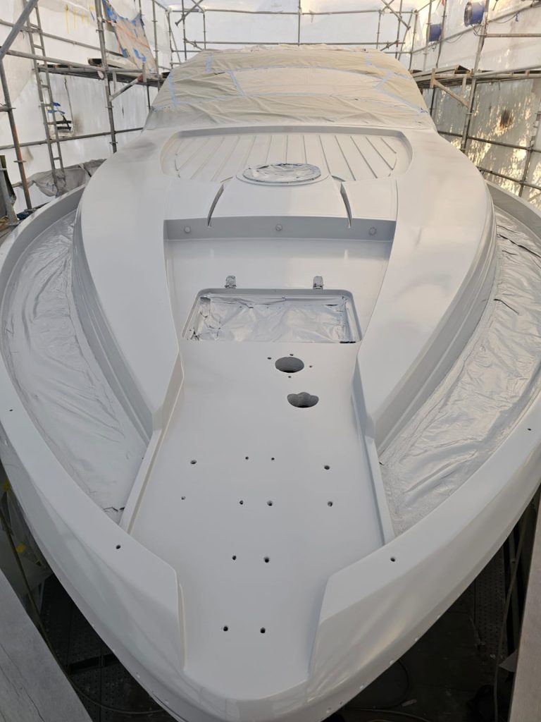 Pershing 64 white foredeck finish with masking and hardware openings still visible