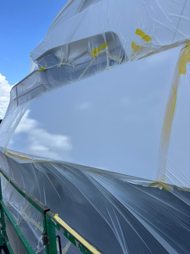 White refinished section on the Sunseeker exterior surrounded by protective plastic and yellow tape